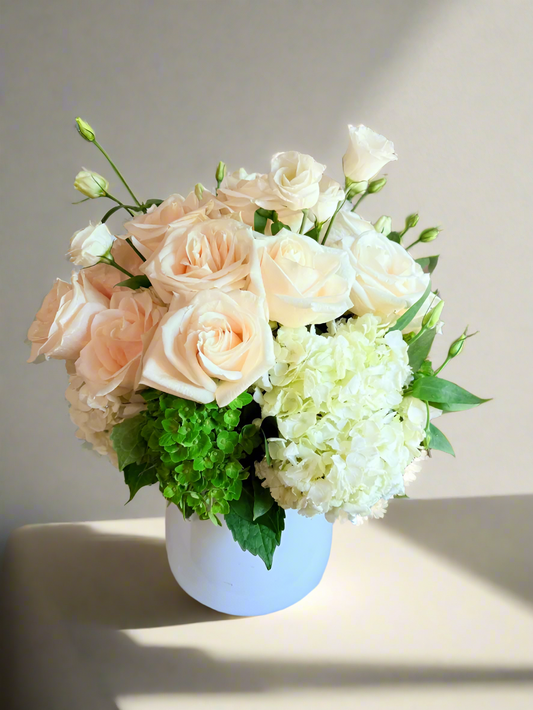 Bouquet of flowers in a white vase on a marble surface with a blurred background